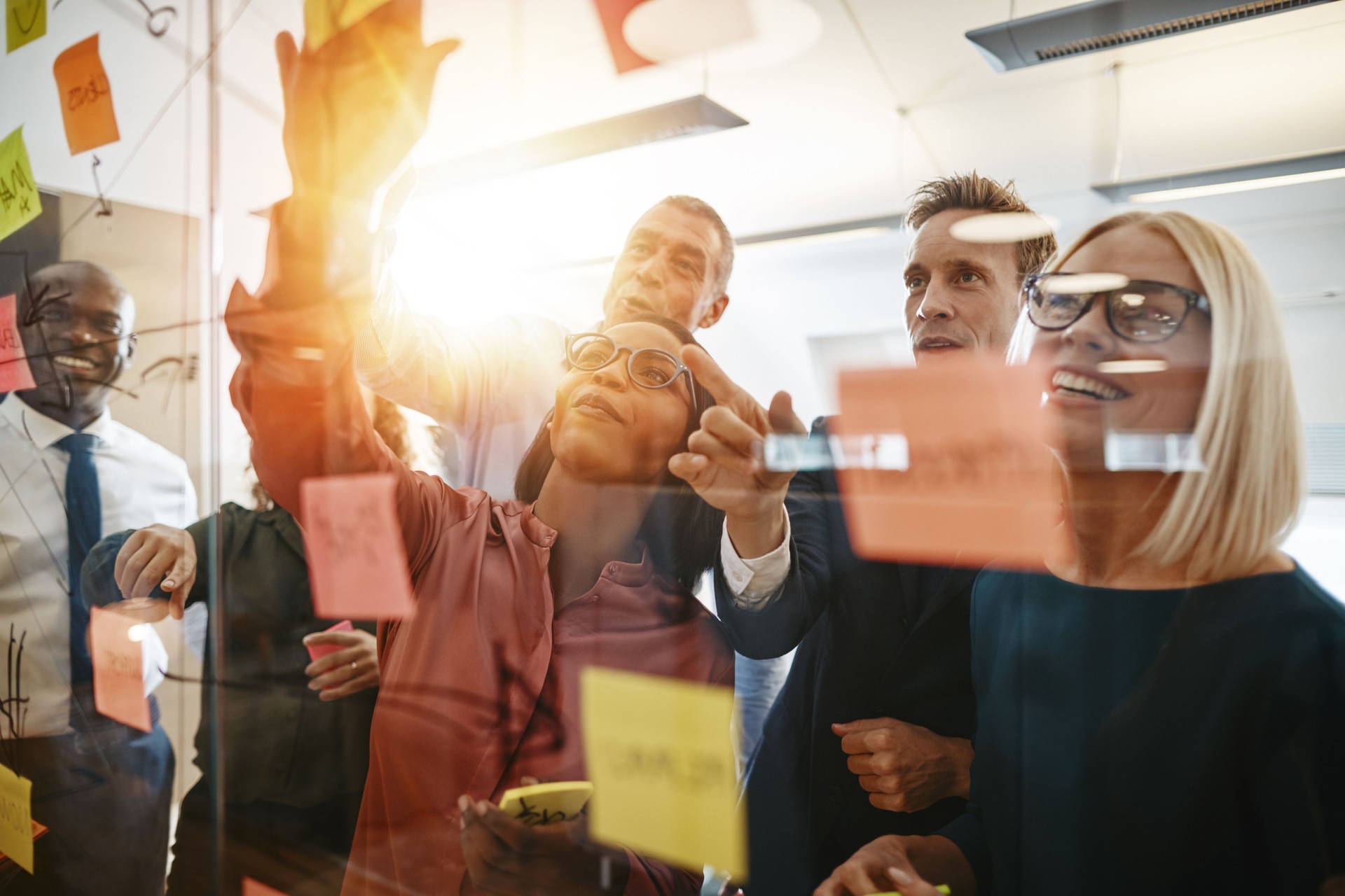 Diverse businesspeople smiling during a brainstorming session with sticky notes